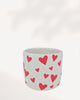 You & Me Hearts Planter front top view, white ceramic and clay planter with scattered red hearts, stylish 3.5 inch cachepot for indoor plants, decorative heart themed planter for desks, shelves and windowsills, modern romantic home décor plant pot